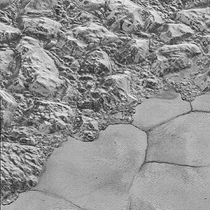  Mountains of ice along a portion of smoother ice planes on Pluto's surface.
